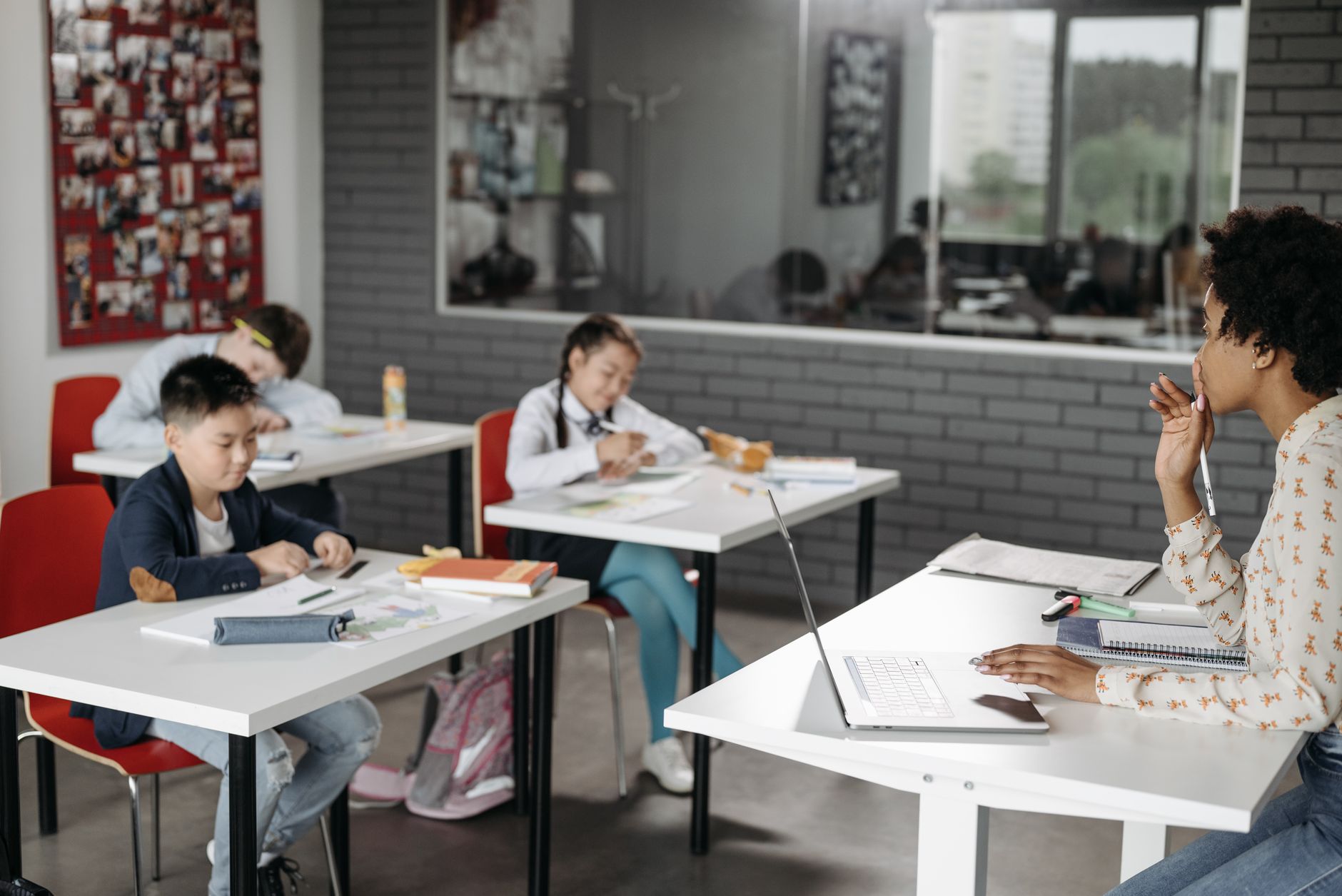 A classroom scene with a teacher and students engaged in learning activities.